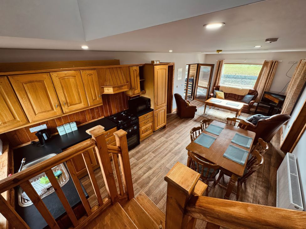 A kitchen and dining area with wooden furniture at Fisherman Lodge No 2 Enniskillen