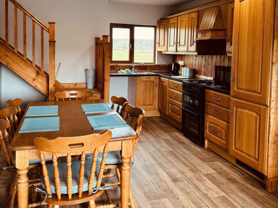 A kitchen with wooden table and chairs at Fisherman Lodge No 2 Enniskillen
