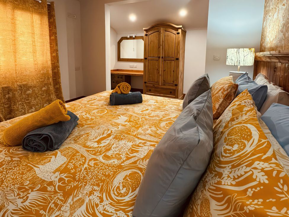 A bedroom with a bed and wardrobe at Fisherman Lodge No 2 Enniskillen