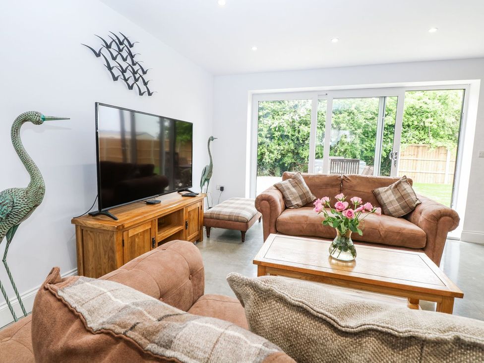 A living room with a sofa and TV at The Ivy in Norwich