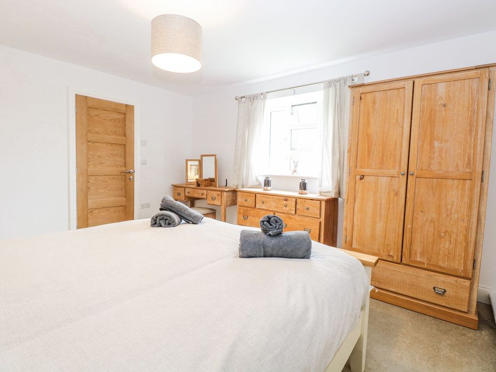 A bedroom with a bed and wooden furniture at The Ivy in Norwich