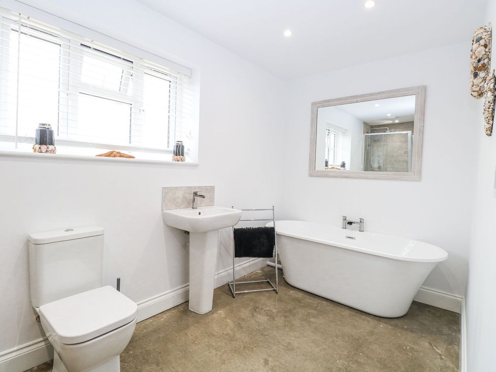 A bathroom with a bathtub, toilet, and sink at The Ivy in Norwich