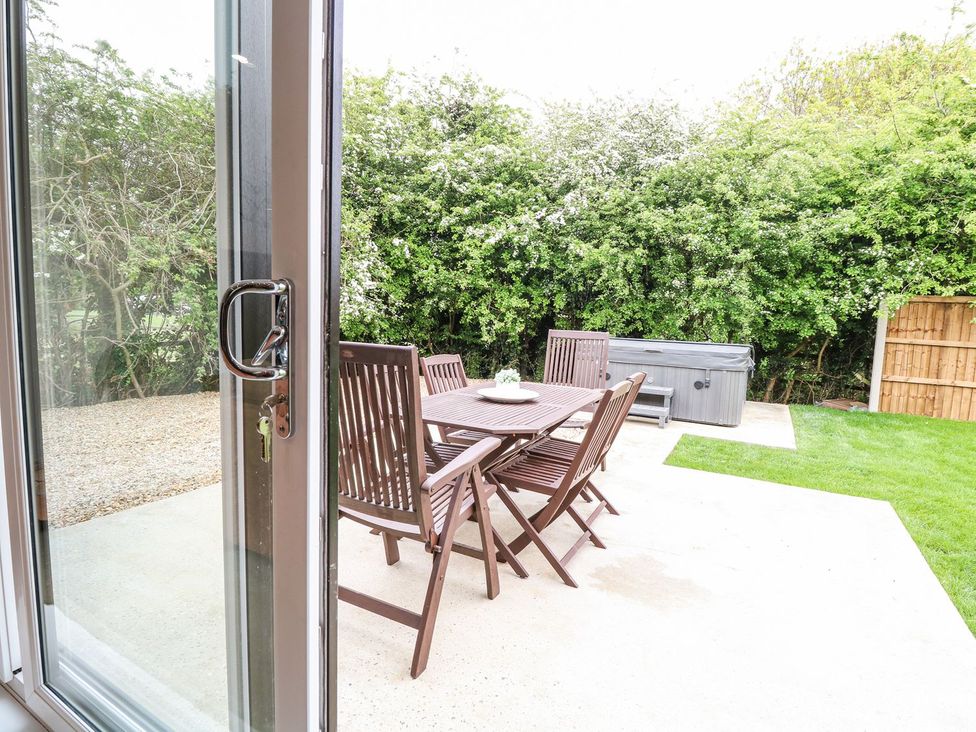 A garden area with a table and chairs and a hot tub at The Ivy in Norwich