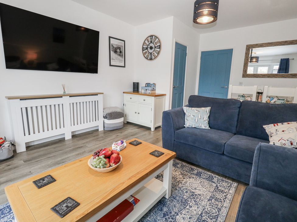 A living room with a television and a coffee table at 8 Park View Grove in Weymouth