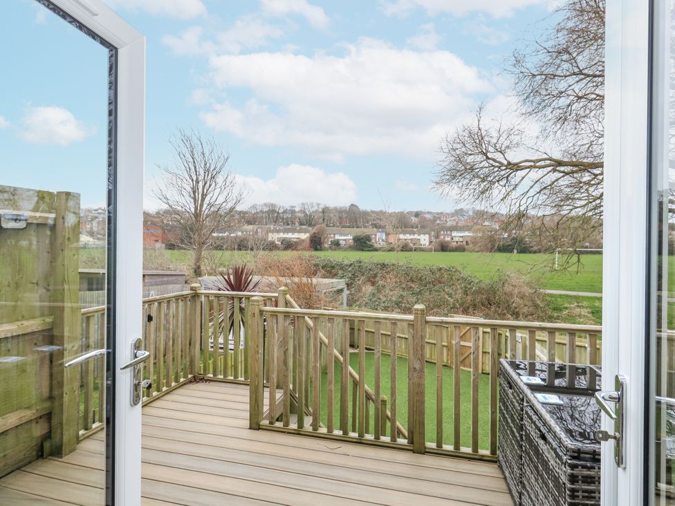 A deck area with railings and a view of grass at 8 Park View Grove in Weymouth