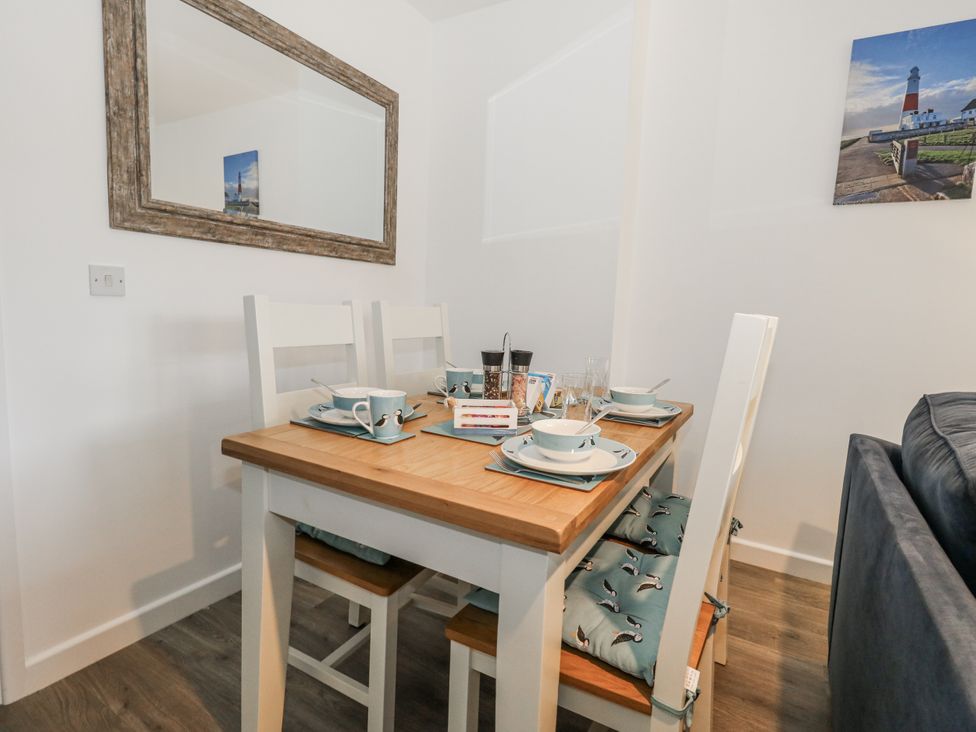 A dining room with a table and chairs at 8 Park View Grove Weymouth