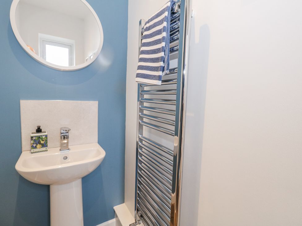 A bathroom with a sink and towel rail at 8 Park View Grove in Weymouth