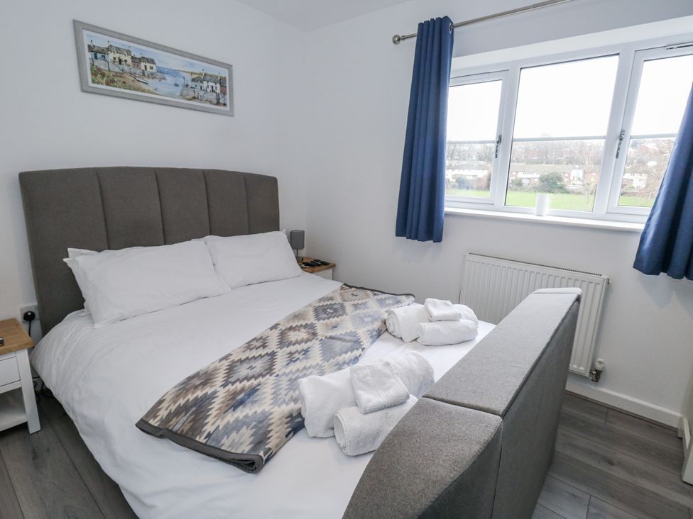A bedroom with a bed and bedside table at 8 Park View Grove in Weymouth