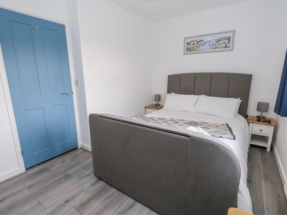 A bedroom with a bed and bedside tables at 8 Park View Grove in Weymouth