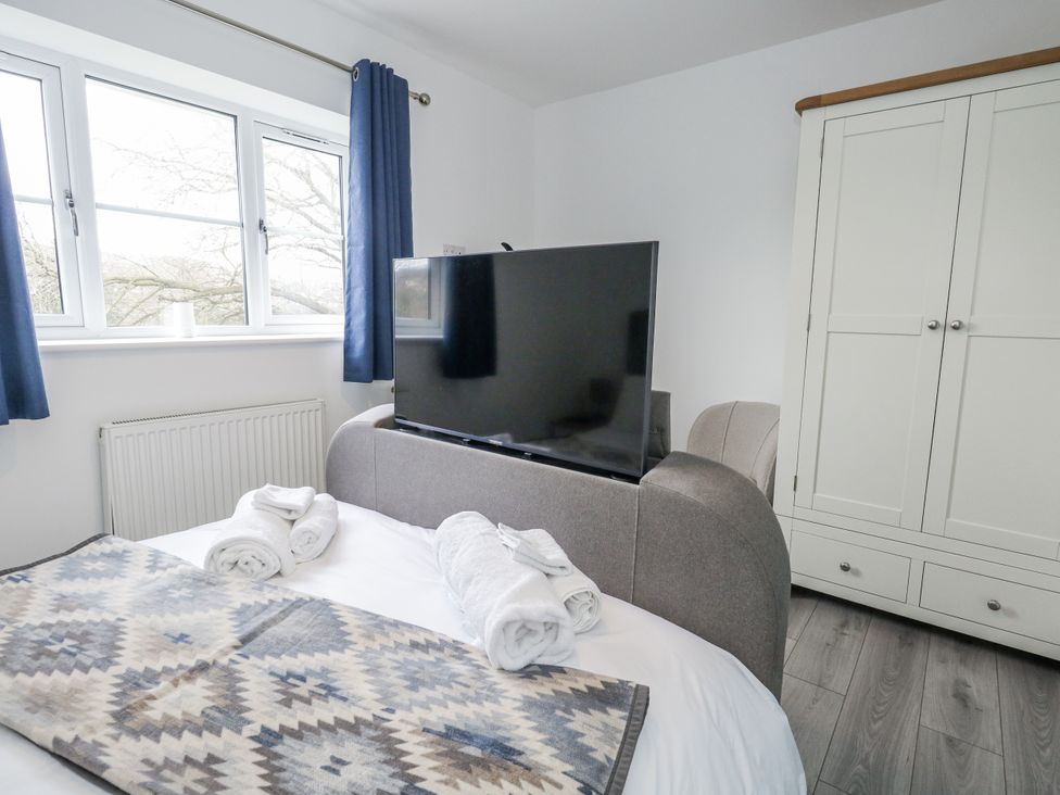 A bedroom with a bed and television at 8 Park View Grove in Weymouth