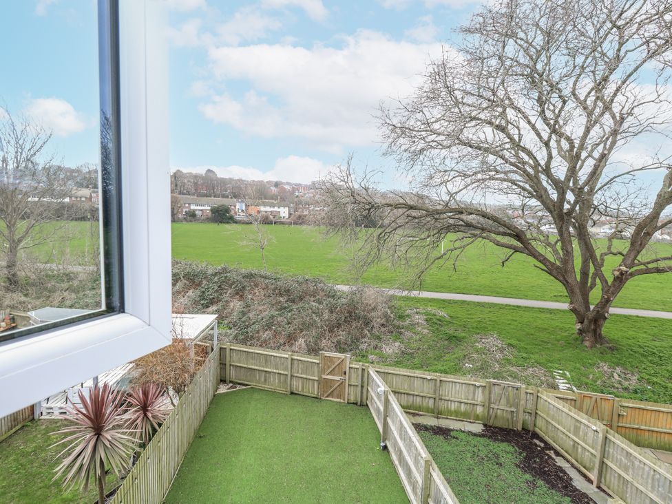 A garden view with a tree and grass area at 8 Park View Grove in Weymouth