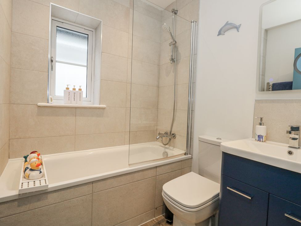 A bathroom with a bathtub and sink at 8 Park View Grove in Weymouth