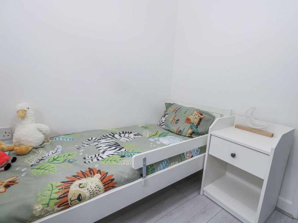 A bedroom with a bed and bedside table at 8 Park View Grove in Weymouth