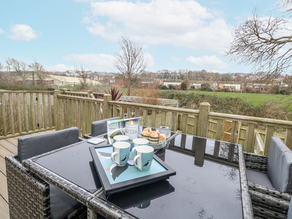 An outdoor dining area with a table set for tea at 8 Park View Grove Weymouth