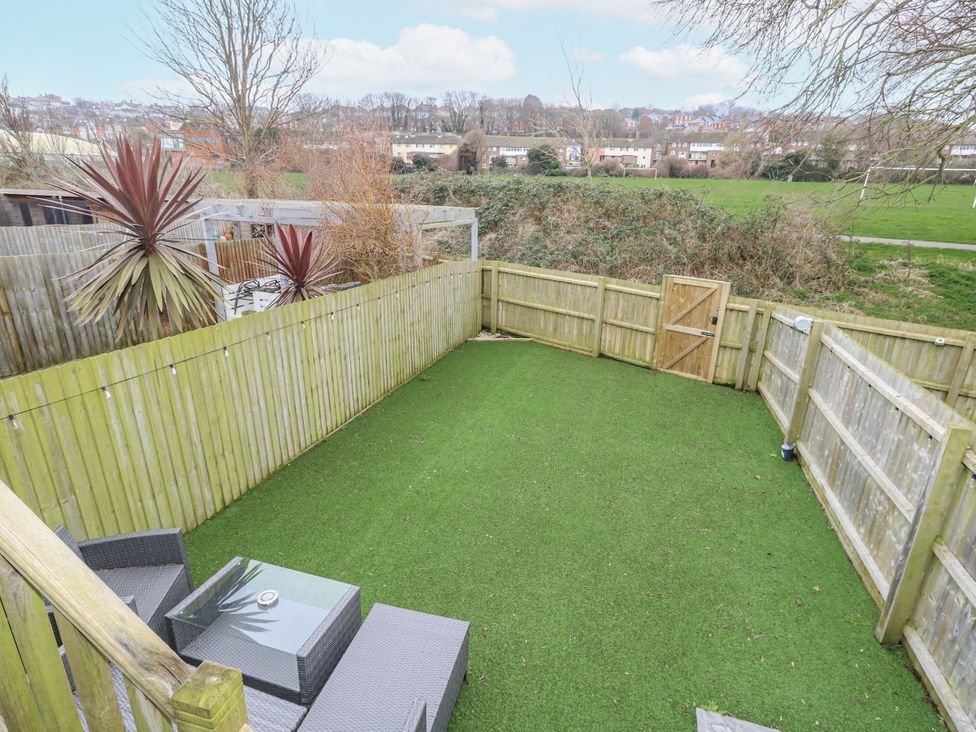 A garden with artificial grass and outdoor furniture at 8 Park View Grove in Weymouth