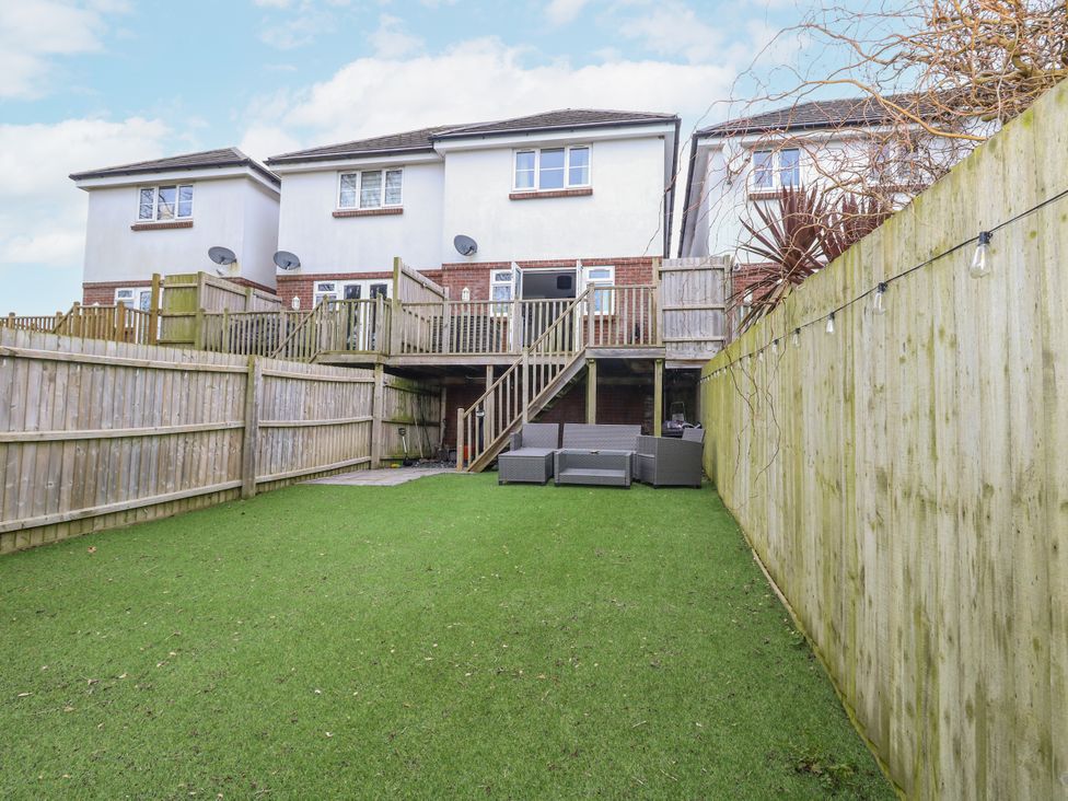 A garden with a decked area and sofa at 8 Park View Grove Weymouth