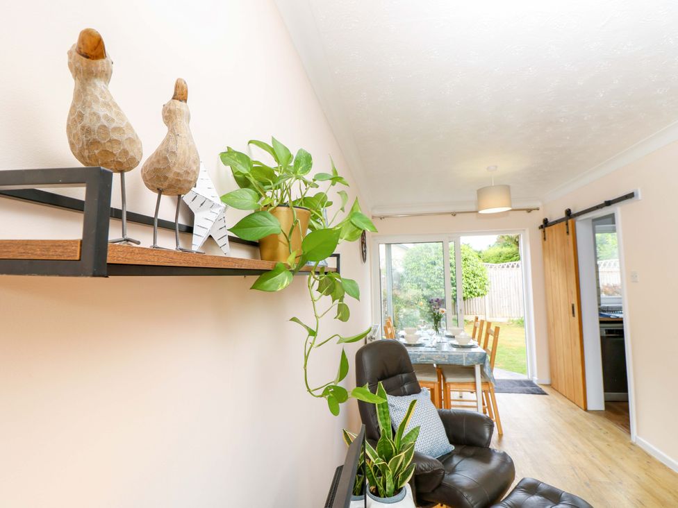 A dining room with a table and chairs at Camellia Cottage in Wimborne Minster