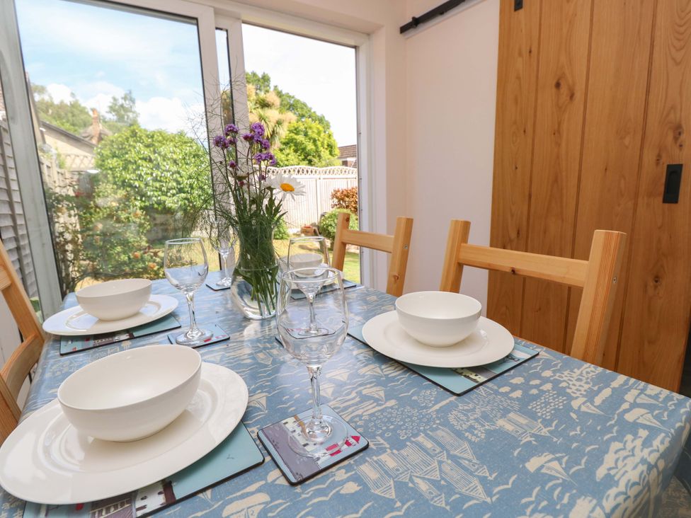 A dining room with a table set for four at Camellia Cottage Wimborne Minster