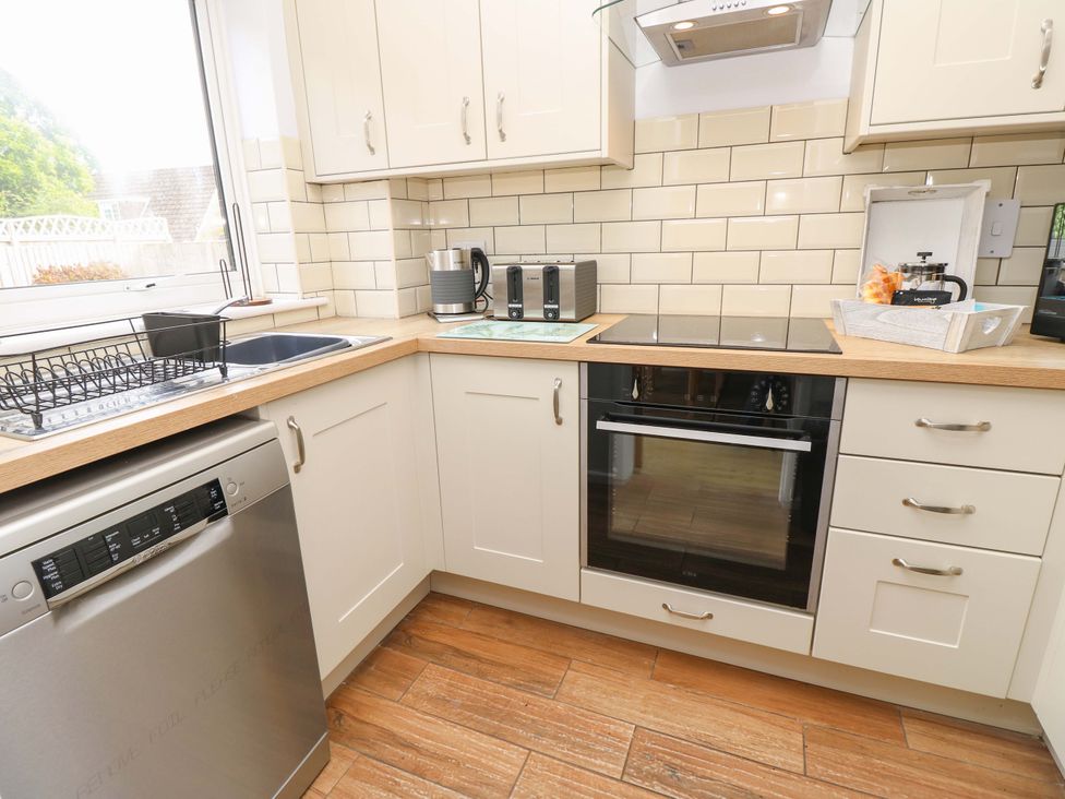 A kitchen with appliances and countertop at Camellia Cottage in Wimborne Minster