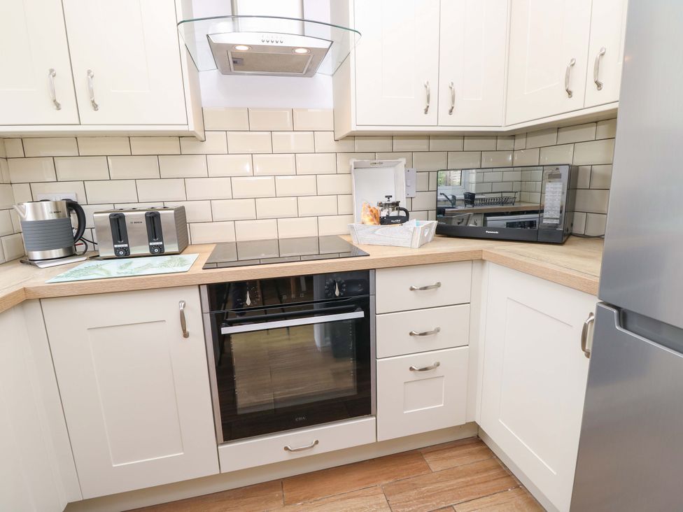 A kitchen with appliances on the countertop at Camellia Cottage in Wimborne Minster