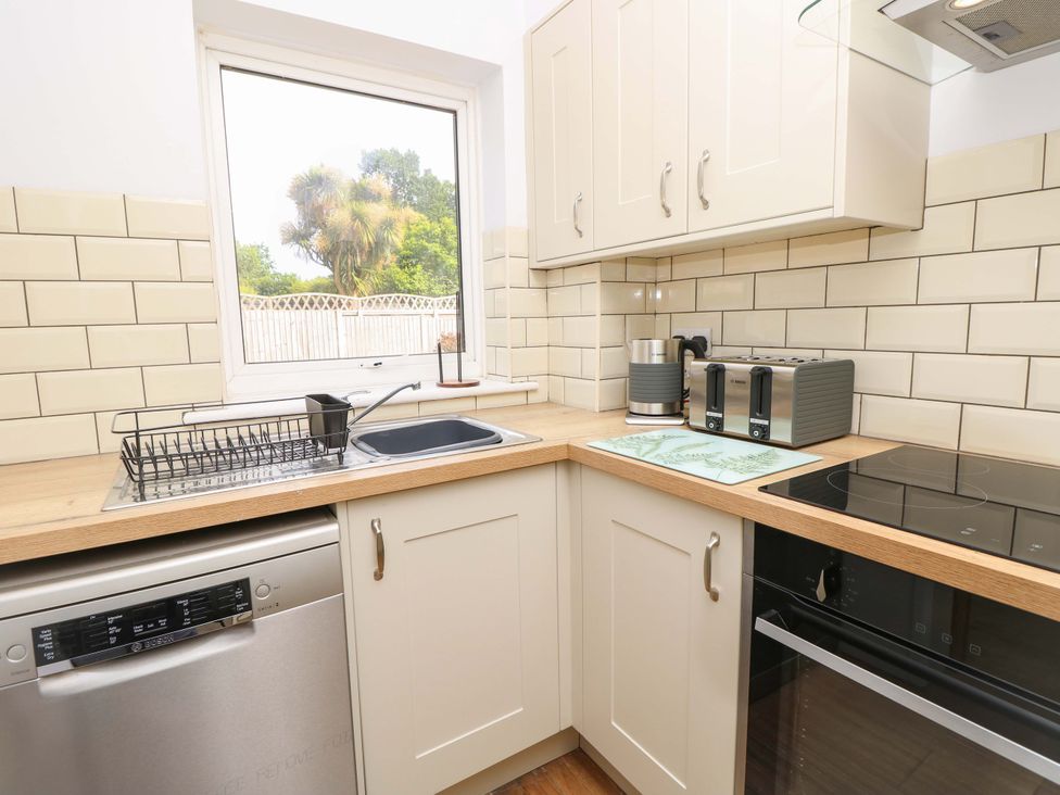 A kitchen with a sink and appliances at Camellia Cottage in Wimborne Minster