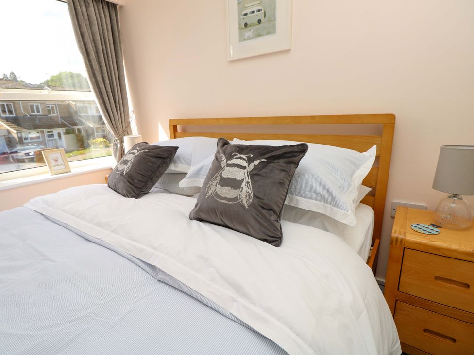 A bedroom with a bed and bedside table at Camellia Cottage in Wimborne Minster