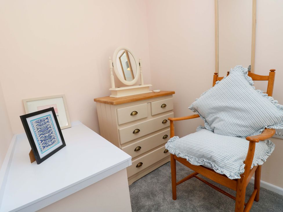 A dressing room with a chair and dressing table at Camellia Cottage in Wimborne Minster