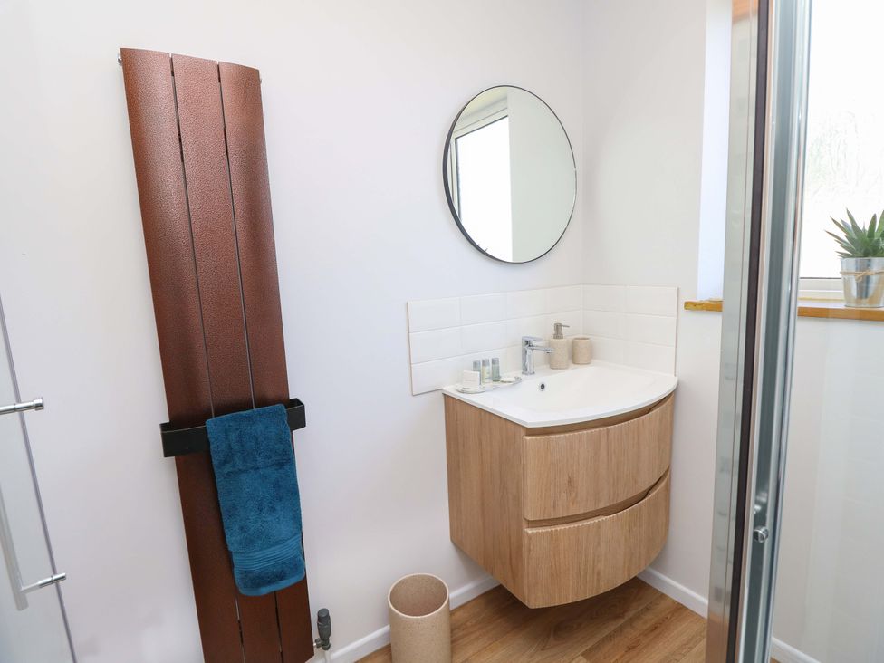 A bathroom with a vanity and mirror at Camellia Cottage in Wimborne Minster