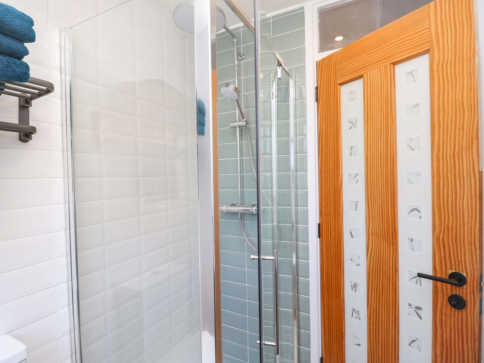 A bathroom with a shower and towels at Camellia Cottage Wimborne Minster