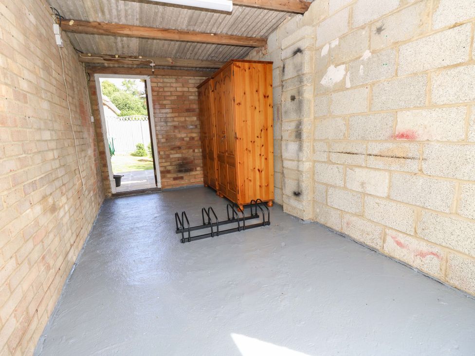 A utility room with a wooden cabinet and a rack at Camellia Cottage Wimborne Minster