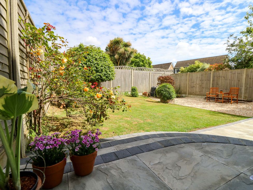 A garden with flowers and seating at Camellia Cottage in Wimborne Minster