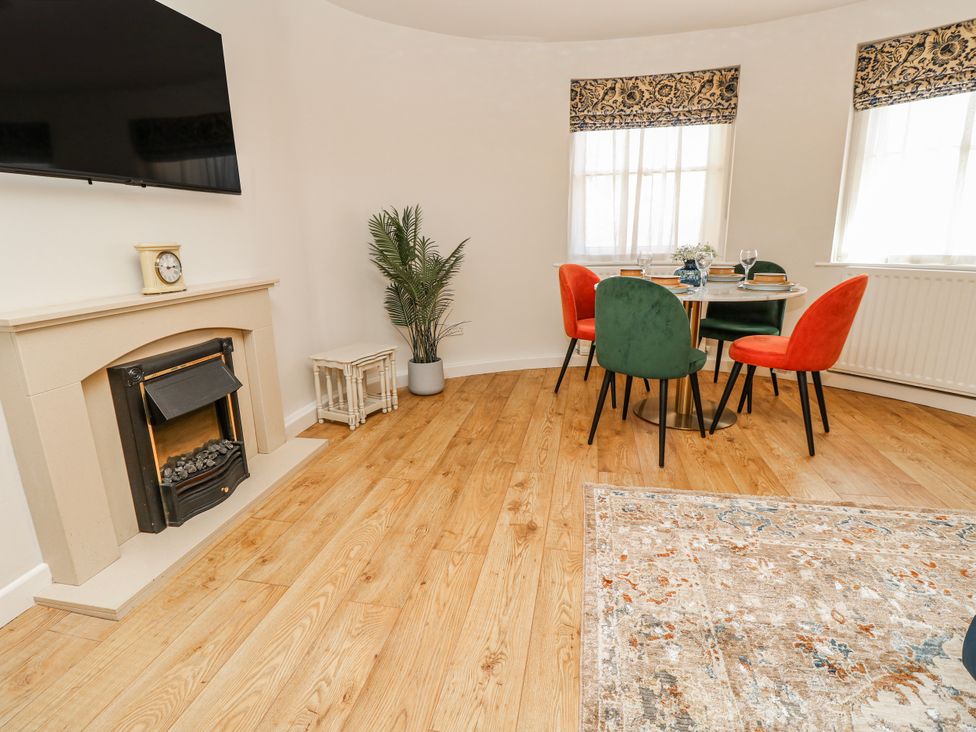 A living room with a fireplace and dining table at 1A Clifton Road in Winchester