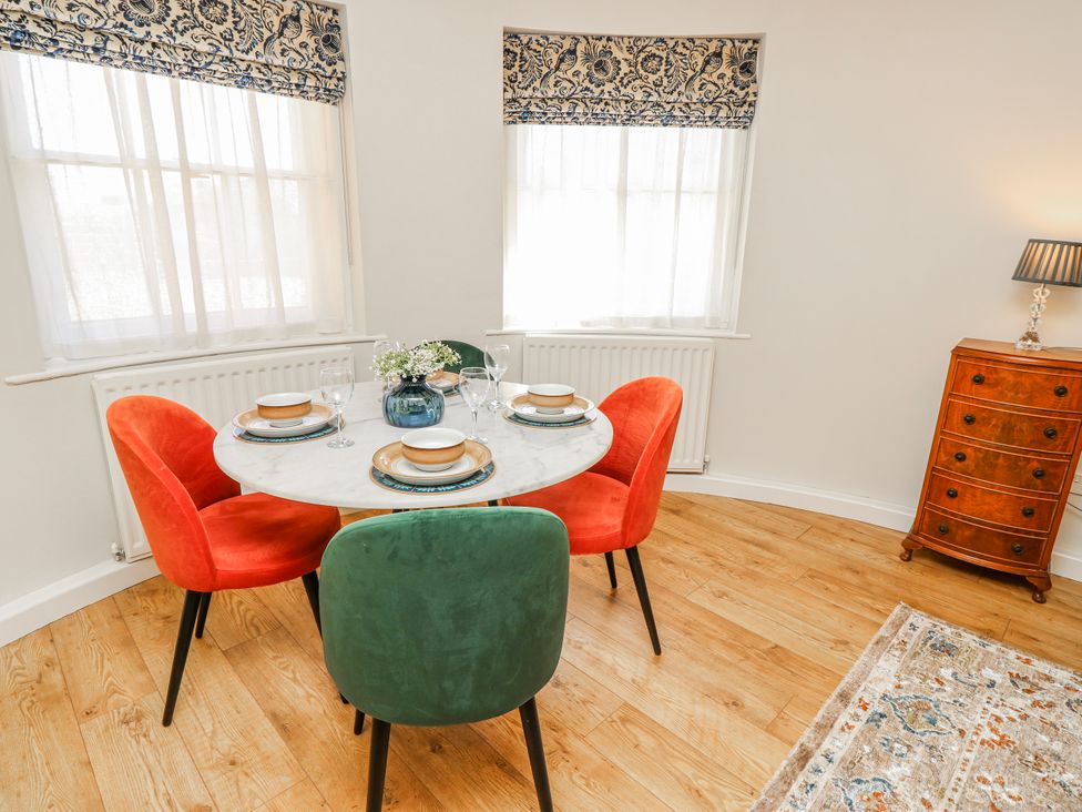 A dining room with a circular table and colorful chairs at 1A Clifton Road Winchester