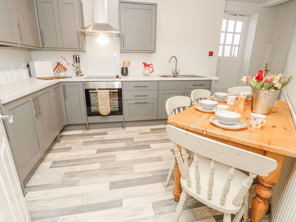 A kitchen with cabinets, a stove, and a wooden table at 1A Clifton Road in Winchester