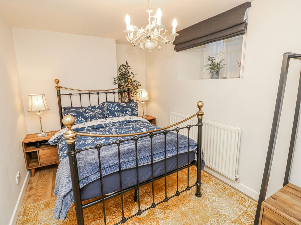 A bedroom with a bed and nightstands at 1A Clifton Road in Winchester
