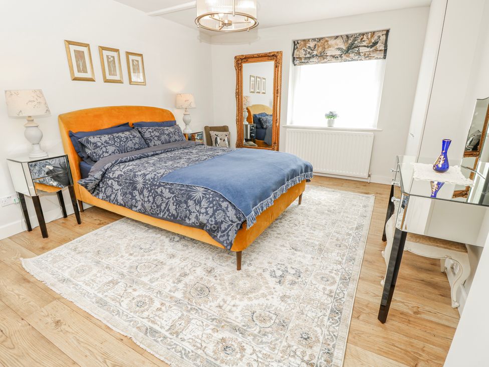 A bedroom with a bed and mirror at 1A Clifton Road in Winchester
