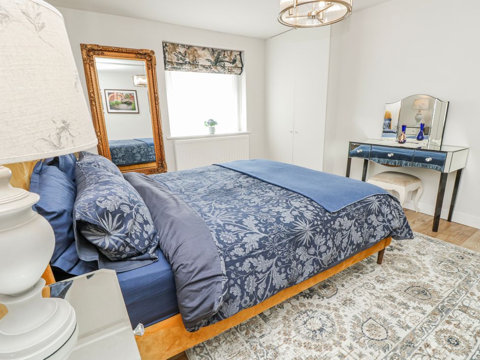 A bedroom with a bed, mirror, and dressing table at 1A Clifton Road in Winchester