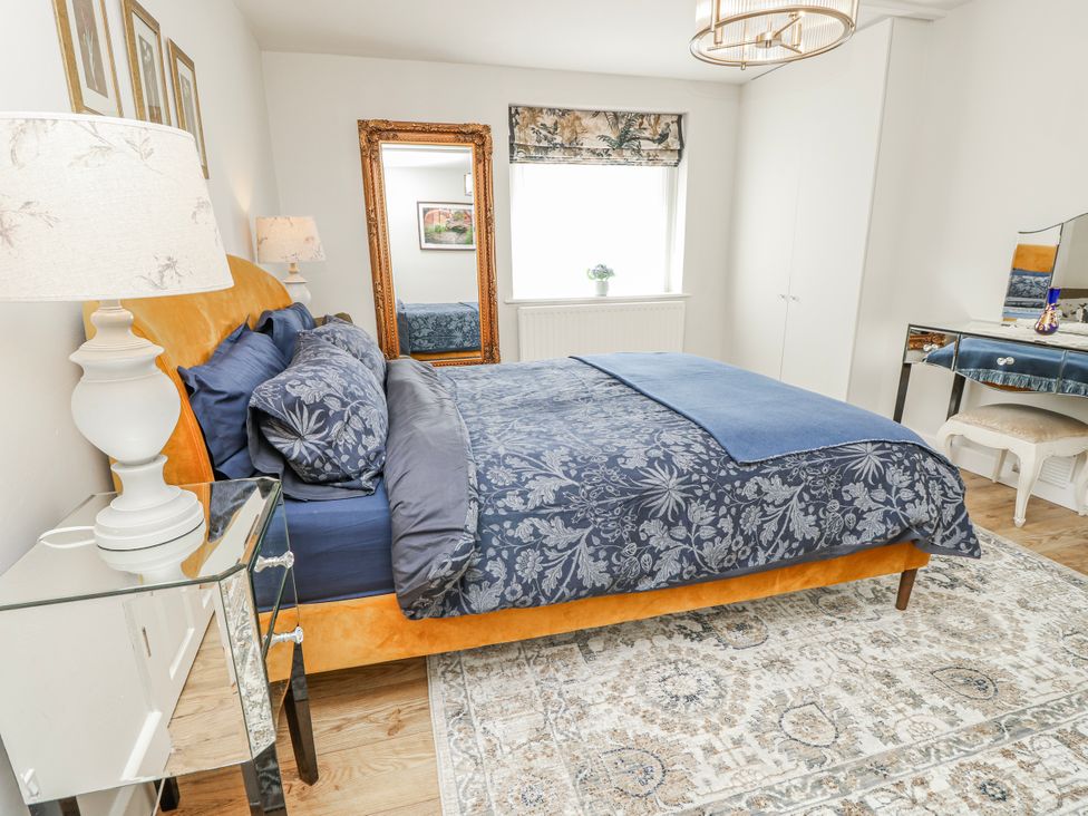 A bedroom with a bed and a mirror at 1A Clifton Road, Winchester
