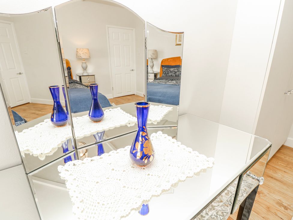 A dresser with a mirror and a vase in a bedroom at 1A Clifton Road Winchester