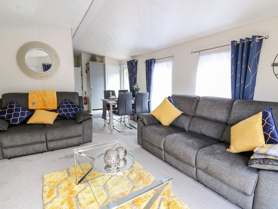 A living room with a coffee table and seating area at 33 Woodpecker Lodge in Llanarth
