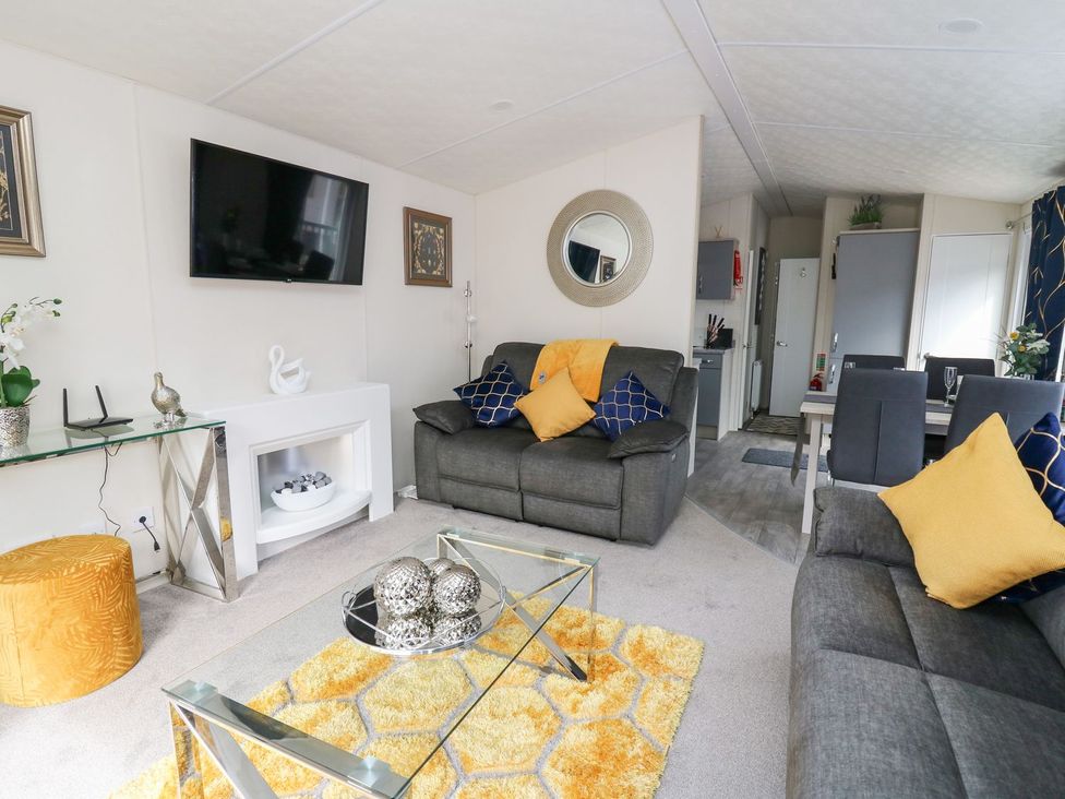 A living room with a sofa and coffee table at 33 Woodpecker Lodge in Llanarth