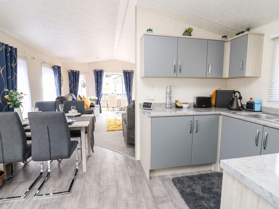 A kitchen with a dining area in 33 Woodpecker Lodge Llanarth