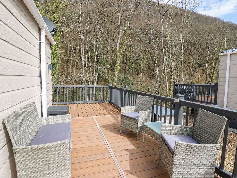 An outdoor patio with chairs and a table at 33 Woodpecker Lodge Llanarth