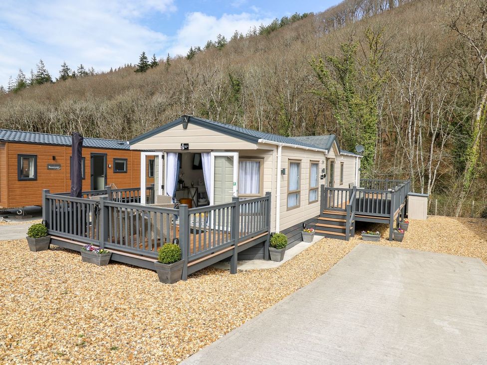 A mobile home with deck and steps at 33 Woodpecker Lodge, Llanarth