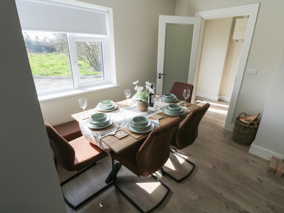 A dining room with a table set for a meal at Doire Fhatharta Beag, Carraroe, County Galway