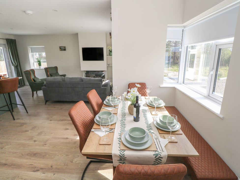 A dining room with a table set for a meal at Doire Fhatharta Beag, Carraroe, County Galway