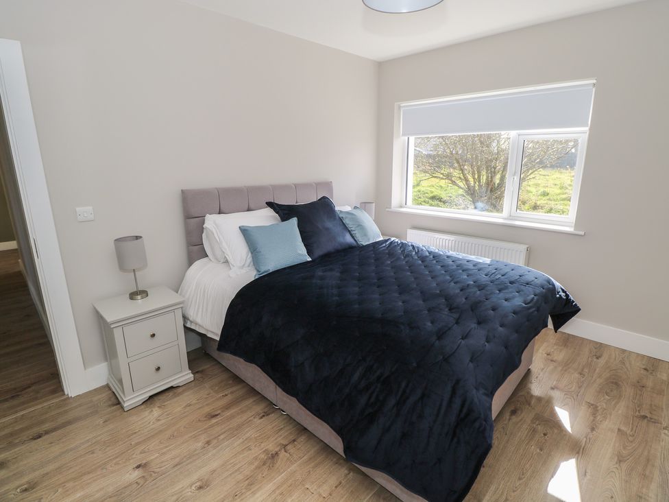 A bedroom with a bed and nightstand at Doire Fhatharta Beag Carraroe, County Galway