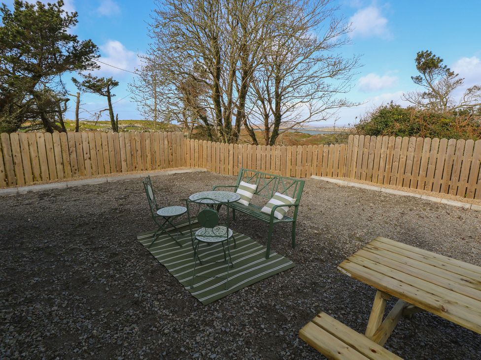 A seating area with a table and chairs at Doire Fhatharta Beag Carraroe, County Galway