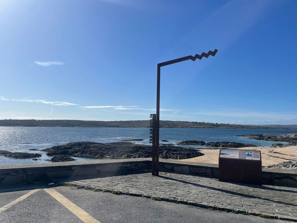 A scenic view with water, rocks, and an information board at Red House, Carraroe, County Galway