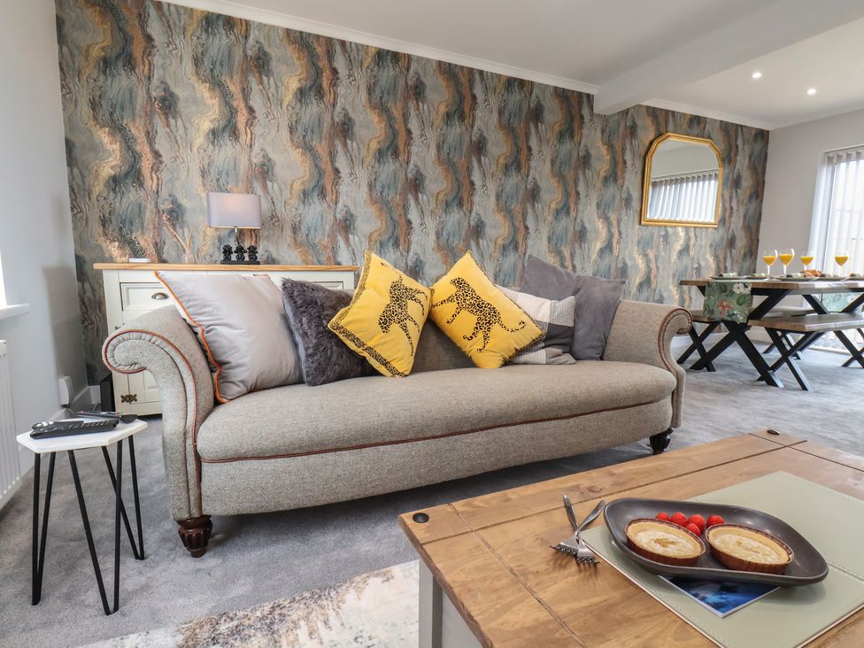 A living room with a sofa and dining table at Sea View House in Marske-By-The-Sea